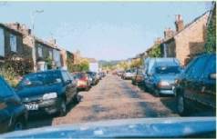 narrow street with cars parked