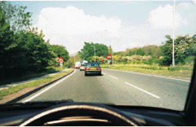 What does the solid white line at the side of the road indicate