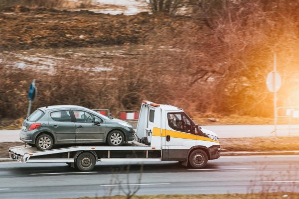 Tow truck towing broken-down vehicle