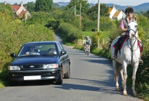 car overtaking horse and rider