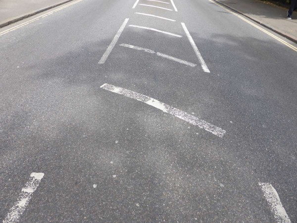 What does it mean when an area of road is painted with white diagonal  stripes and surrounded by a broken white line? - Theory Test